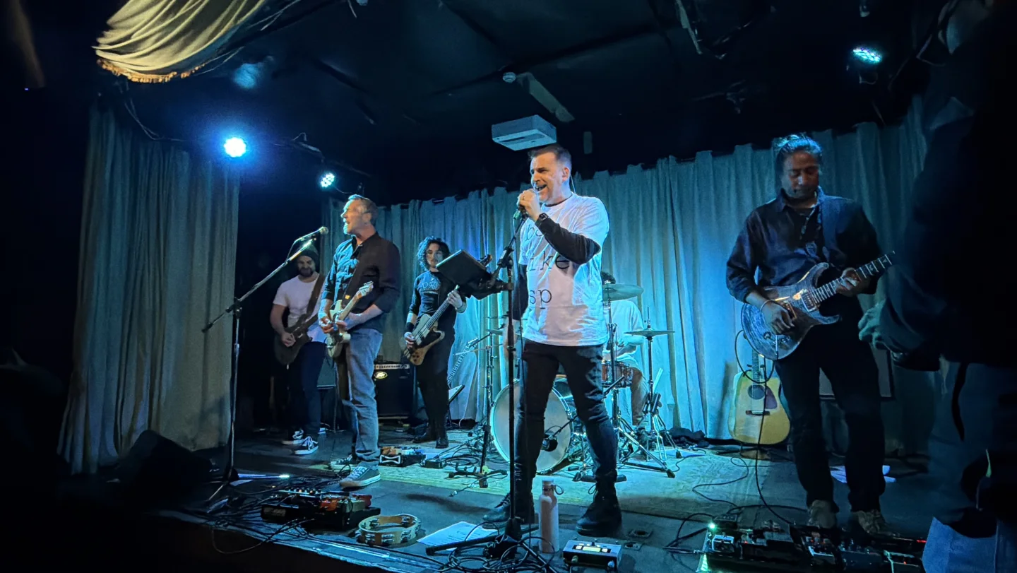Ian Cope fronting the Rising Sun Pictures company band with the group performing on stage
